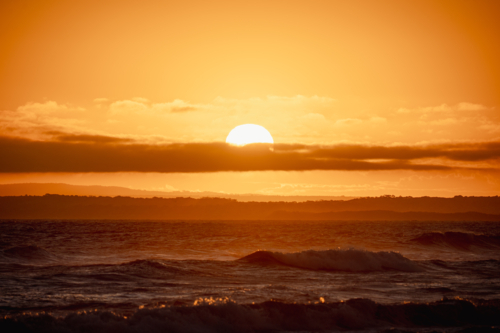 Vivid sunset over ocean with golden reflections - Australian Stock Image