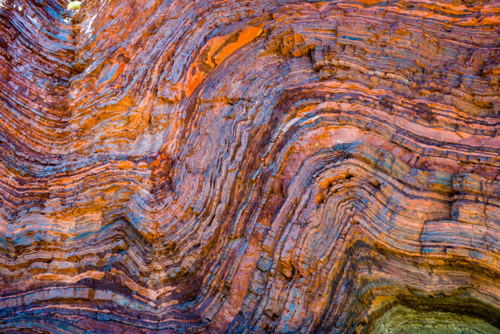 Vividly coloured and contorted rock strata in ancient layered gorge walls - Australian Stock Image