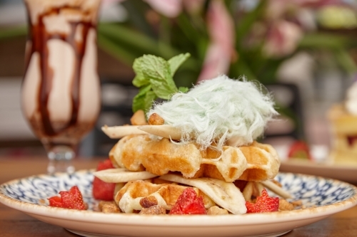 Waffle dessert with chocolate milkshake on table - Australian Stock Image