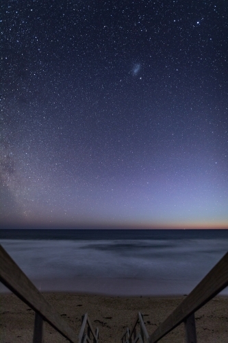 Walkway leading down to beach at night with stars - Australian Stock Image