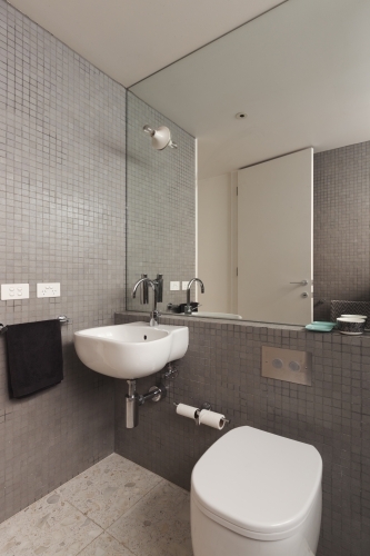Wall mounted basin vanity in fully tiled mosaic modern bathroom - Australian Stock Image