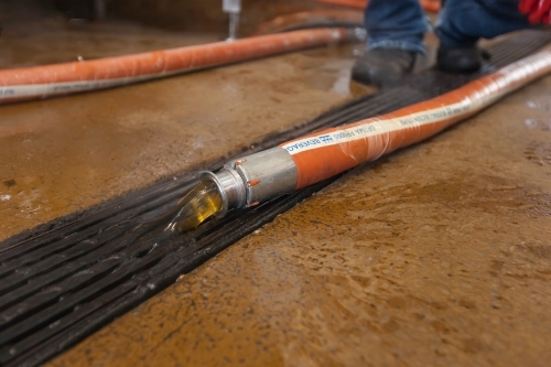 Waste water pouring down drain at a microbrewery - Australian Stock Image