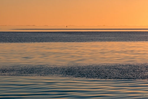 Water patterns on the calm ocean at sunset - Australian Stock Image