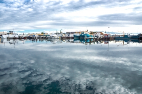 Water reflections of a boat harbour and skyline - Australian Stock Image