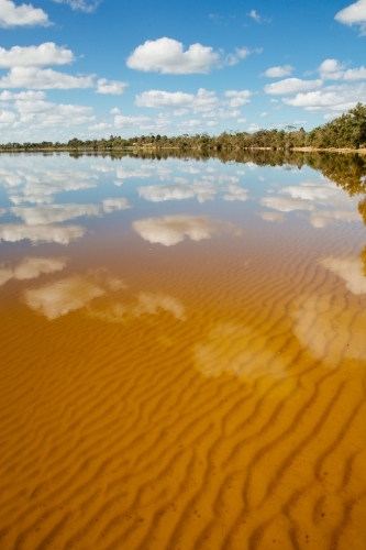 Water reflections of clouds and sky on a glassy lake - Australian Stock Image