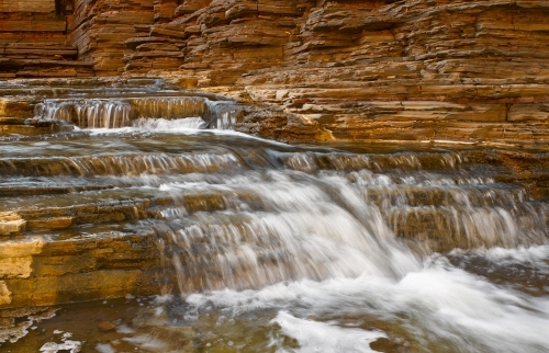 Waterfall flowing over rocks in national park - Australian Stock Image
