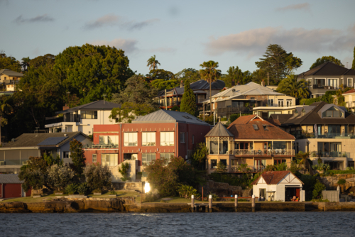 Waterfront homes along the Parramatta River in golden afternoon sunshine - Australian Stock Image
