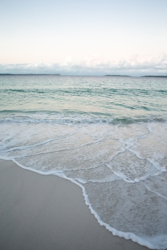 Waves and sea foam flowing against the shore - Australian Stock Image