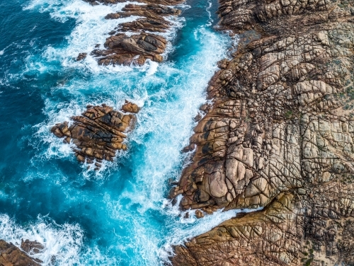 Waves crash against rugged coastal rocks