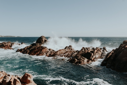 Waves crashing on rock formations just off coastline - Australian Stock Image