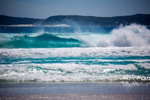 Waves crashing onto a beach with turquoise water - Australian Stock Image
