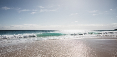 Waves on beach in morning light - Australian Stock Image