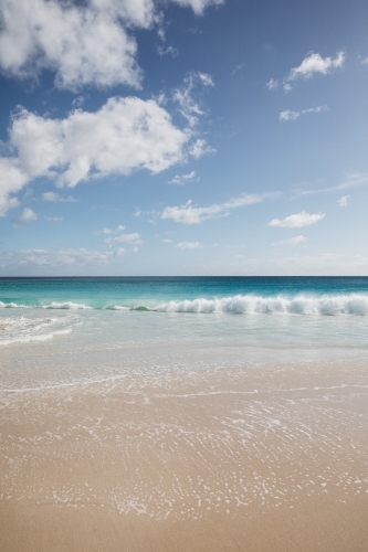 Waves on empty beach in morning light - Australian Stock Image