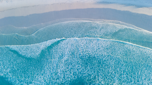 Waves rolling onto the sandy shoreline - Australian Stock Image