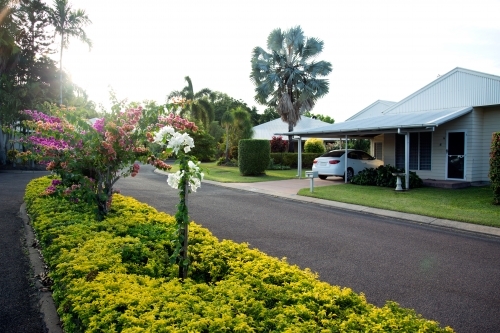 Weatherboard home in a picturesque street with hedge in the middle of the road. - Australian Stock Image