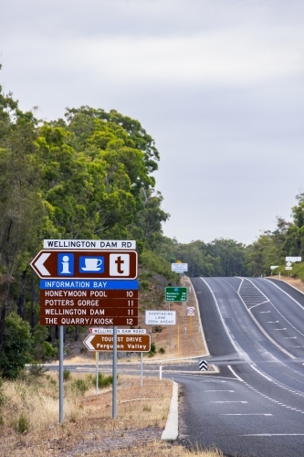 Wellington Dam Road turnoff on highway with many signs at the intersection - Australian Stock Image