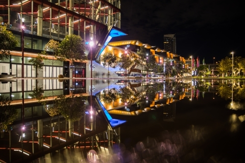 Wet pavement reflection of the new International Convention Centre Sydney illuminated at night - Australian Stock Image