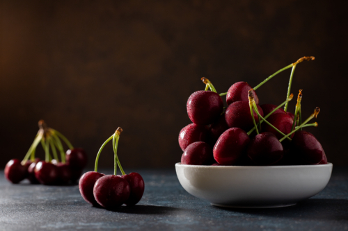 wet red cherries on a plate - Australian Stock Image
