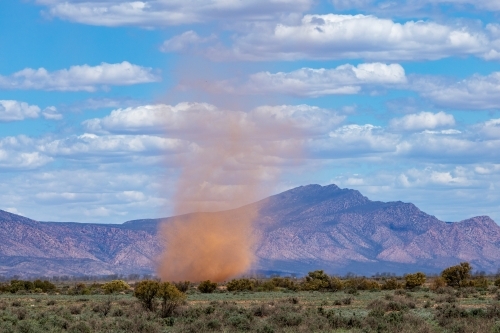 whirlwind on plains with rugged hills - Australian Stock Image
