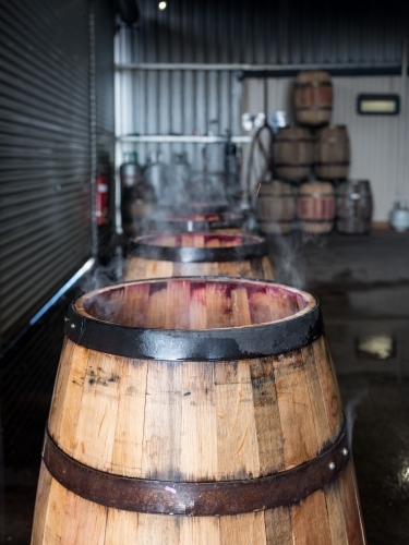 Whisky barrels are lined up while being charred for storage - Australian Stock Image