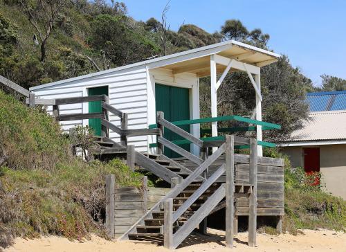 White and green beach box leading down to the sand on a sunny day - Australian Stock Image