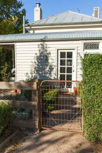 White house with an old rusty gate - Australian Stock Image