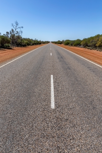 White line down middle of long, empty, straight road in rural Western Australia