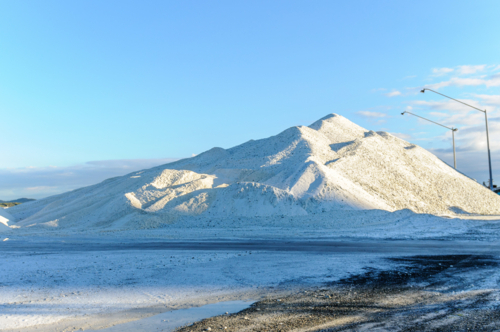 White mineral mound at industrial storage site - Australian Stock Image