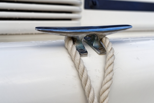 White ropes and silver cleats detail on white yacht rigging - Australian Stock Image