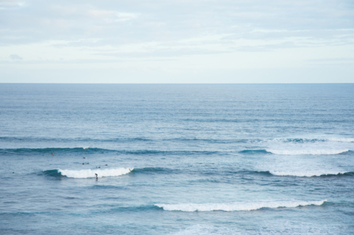 Wide shot of surfers catching waves on ocean break - Australian Stock Image