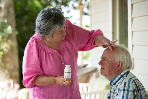 Wife taking care of her husband applying sunscreen - Australian Stock Image