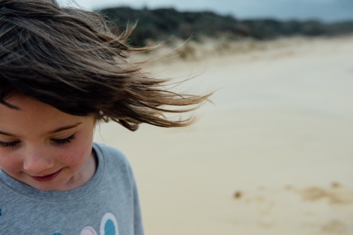 Wind blowing brunette girls hair - Australian Stock Image