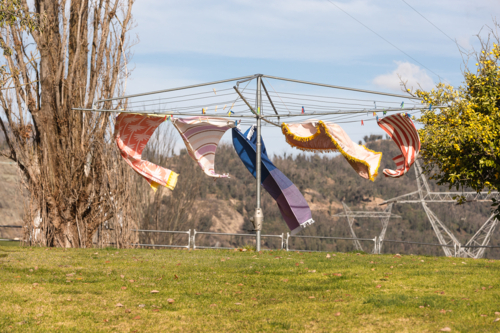 Wind blowing towels on hills hoist with Snowy Hydro in the background - Australian Stock Image