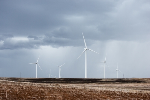 Wind farm in paddock with incoming storm - Australian Stock Image