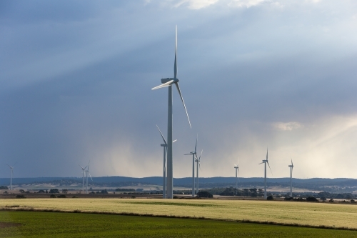 Wind farm in paddocks with approaching storm - Australian Stock Image