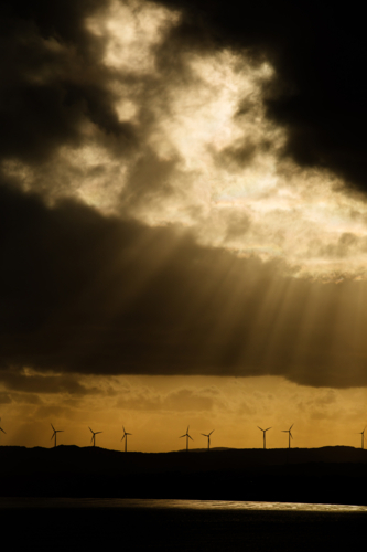 Wind turbines and golden rays and moody clouds - Australian Stock Image