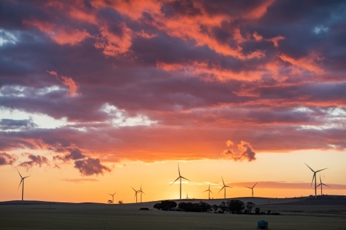 wind turbines in farmland against sunset sky - Australian Stock Image