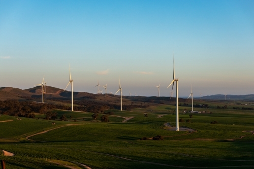 wind turbines in rolling landscape at dusk - Australian Stock Image