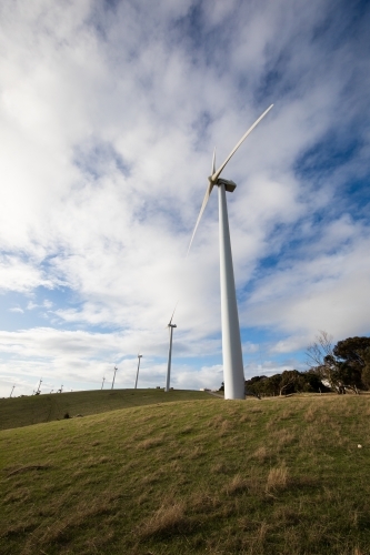 Wind turbines on a bare grassy hill exposed to offshore winds on the Fleurieu Peninsula - Australian Stock Image