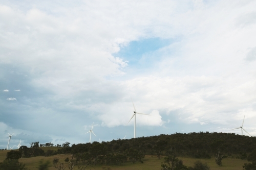 Wind turbines on a hill on a cloudy day - Australian Stock Image