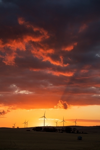 wind turbines silhouetted against sunset sky, vertical - Australian Stock Image