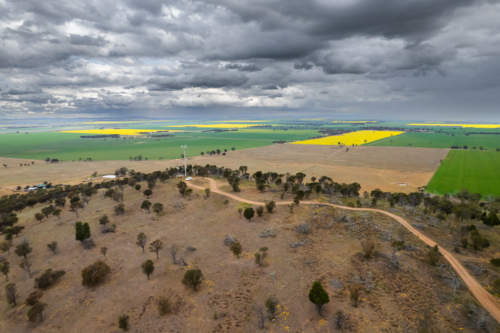 Winding dirt road in sparsely vegetated land - Australian Stock Image