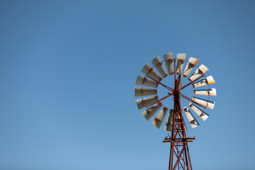 Windmill against bright blue summer sky - Australian Stock Image