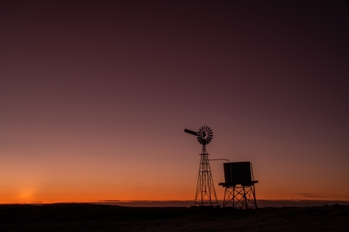 Windmill in a field in the early hours of dawn. - Australian Stock Image