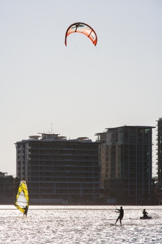 Windsurfing and kitesurfing at a river in a city - Australian Stock Image