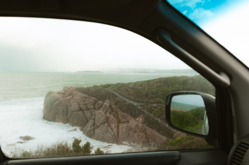 Winter view of clifftop walking trail at Green Bay through car window - Australian Stock Image