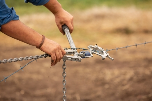 Wire strainers being used to build a new fence - Australian Stock Image
