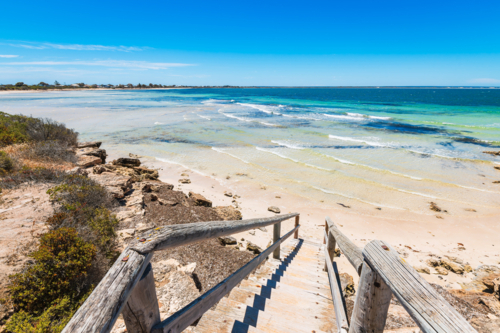 Woden boardwalk with seaside landscape of Penguin Point Bay under blue sky, on a bright day - Australian Stock Image