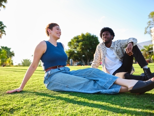 Woman and man sitting together in a park - Australian Stock Image