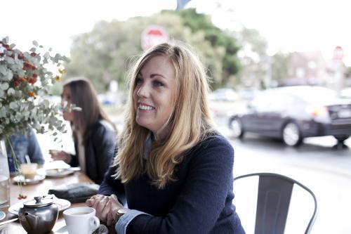 Woman at cafe smiling and looking to the side